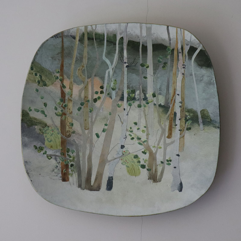 large ceramic platter painted to depict hazel woodland.
