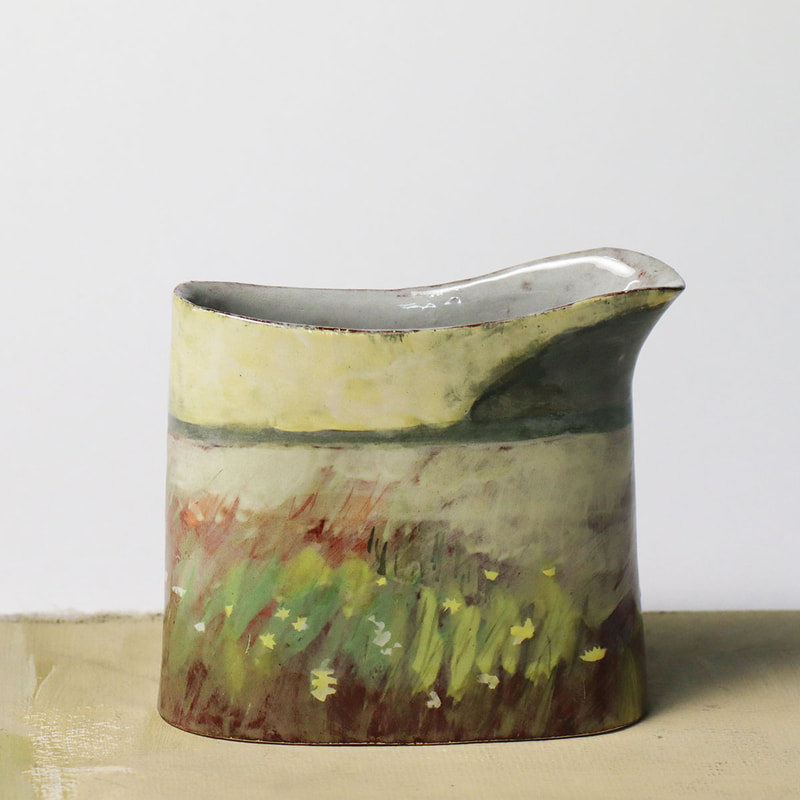 small handbuilt ceramic jug painted with slips, depicting ancient hay meadow in June