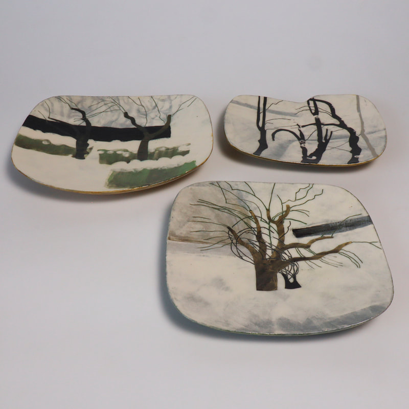 handformed ceramic plates slip painted with images of apple and bird cherry trees.